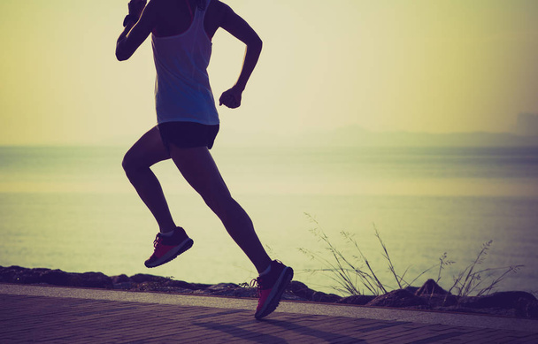 Esportista de fitness correndo na costa ensolarada
 - Foto, Imagem