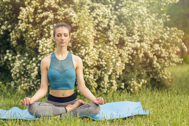 Young Caucasian woman meditating in Lotus position. Yoga in the  - Photo, Image