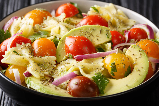 Farfalle pasta salad recipe with ripe avocado, onions and tomato - Photo, image