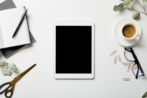 digitális tabletta, növények, papíráruk, olló, kávé, poharak és notebookok felülnézete fehér felületen lévő tollal - Fotó, kép