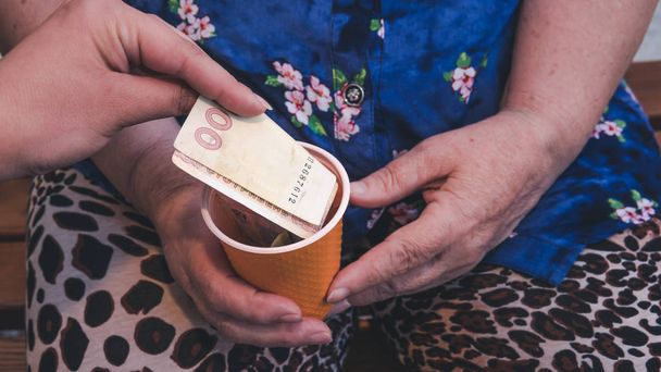 La anciana ruega limosna. Primer plano de dinero y monedas en mano de p
 - Foto, imagen