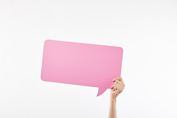 白で隔離された手にピンクのスピーチバブルを持つ女性のトリミングされたビュー - 写真・画像