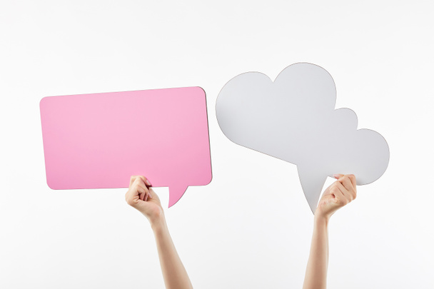 cropped view of woman with pink thought and speech bubbles in hands isolated on white - Foto, afbeelding