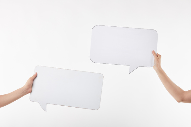 cropped view of two women with speech bubbles in hands isolated on white - Photo, Image