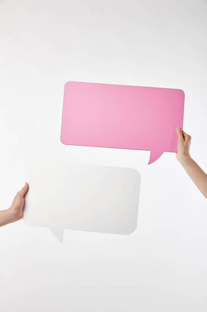 cropped view of two women with speech bubbles in hands isolated on white - Фото, изображение