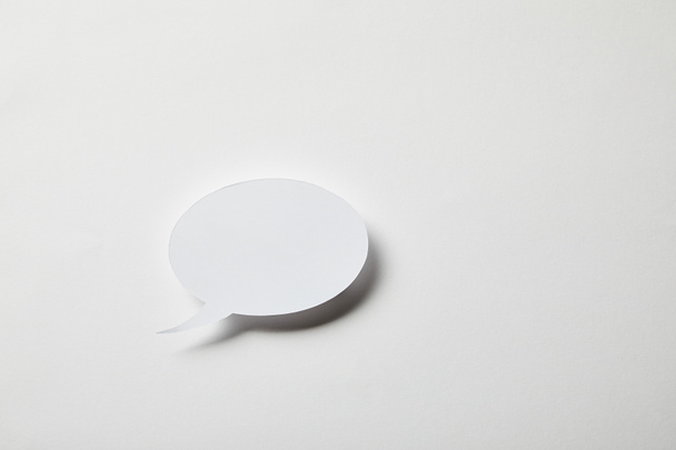small paper speech bubble on white surface  - Foto, afbeelding