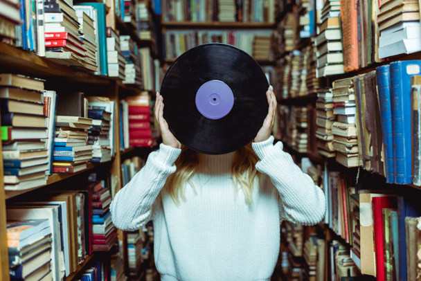 cropped view of young adult woman holding vinyl in library  - Valokuva, kuva