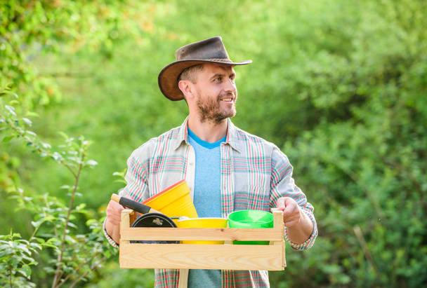 sexy farmer hold wooden box with flower pot. farming and agriculture cultivation. Garden equipment. Eco farm worker. happy earth day. Eco living. muscular ranch man in cowboy hat. Working with flower - Foto, Imagem