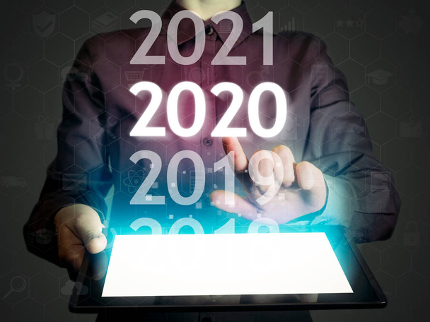 Жінка вибирає 2020 на планшетному ПК. Новий 2020 рік у високих технологіях
. - Фото, зображення
