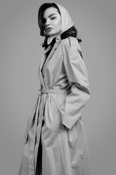 Joven mujer morena elegante en abrigo y chal posando en estudio
 - Foto, imagen