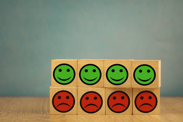 Lächelnde und traurige Emoticons auf blauem Hintergrund. Zufriedenheitskonzept - Foto, Bild