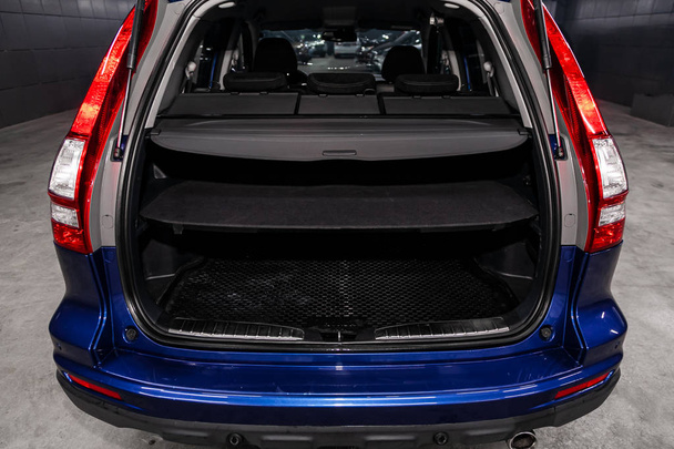Primo piano Vista posteriore di un SUV auto blu con tronco aperto in garage. Bagagliaio vuoto dell'auto
 - Foto, immagini