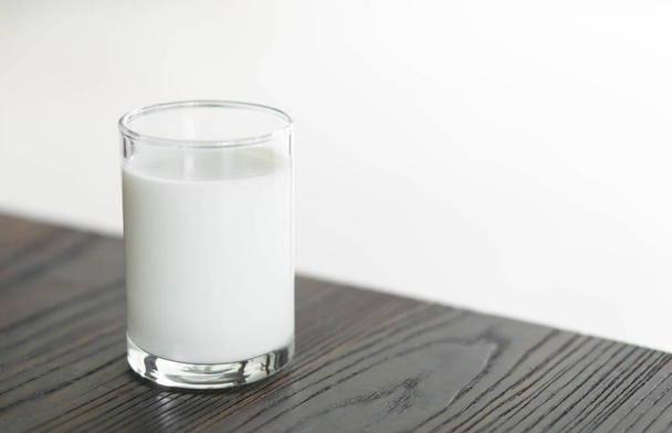 Κλείστε το ποτήρι γάλα σε ξύλινο τραπέζι, επιλεκτική εστίαση - Φωτογραφία, εικόνα