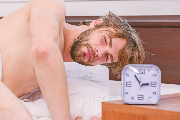 Homme paresseux heureux de se réveiller dans le lit levant les mains le matin avec une sensation de fraîcheur détendue. Pieds d'homme dormant dans un lit confortable. Homme se réveillant au lit
. - Photo, image