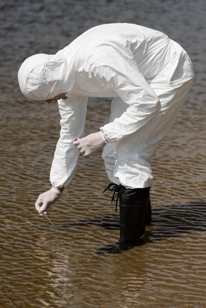 inspector de agua en guantes de látex con tubo de ensayo que toma muestra de agua
 - Foto, Imagen
