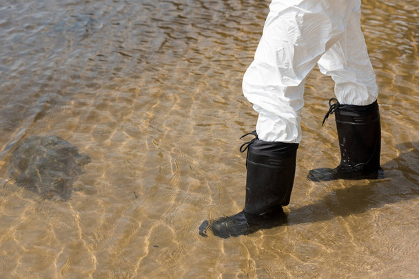 cropped view of water inspector in protective costume and boots standing in river - Photo, image