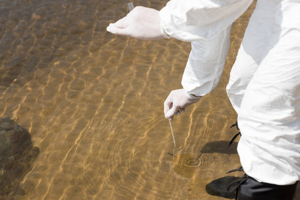 partial view of water inspector in latex gloves with test tube taking water sample - Photo, Image