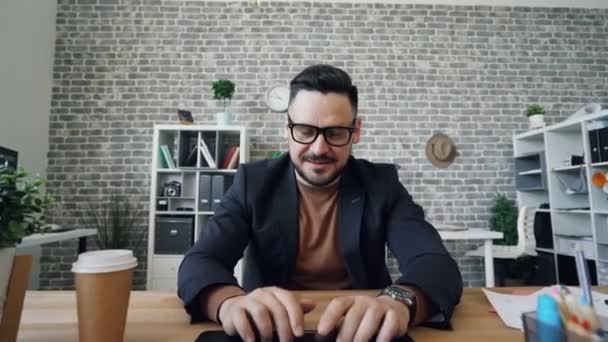 Zoom-in portrait of handsome man working with laptop typing in office - Кадри, відео