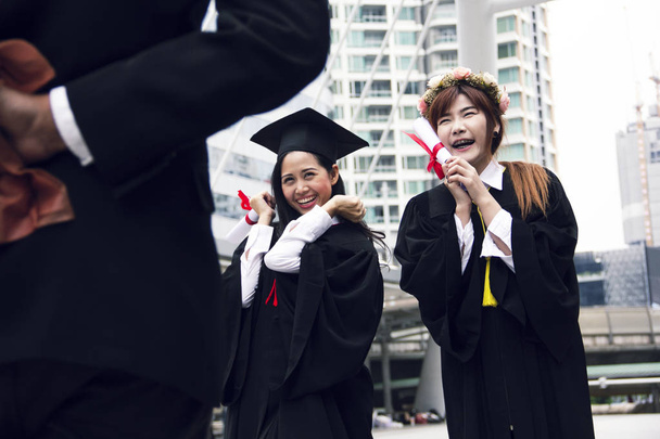 Όμορφο απόφοιτο πτυχιούχοι δύο Ασία γυναίκα χαμόγελο και είναι χαρούμενοι μετά την αποφοίτηση. - Φωτογραφία, εικόνα