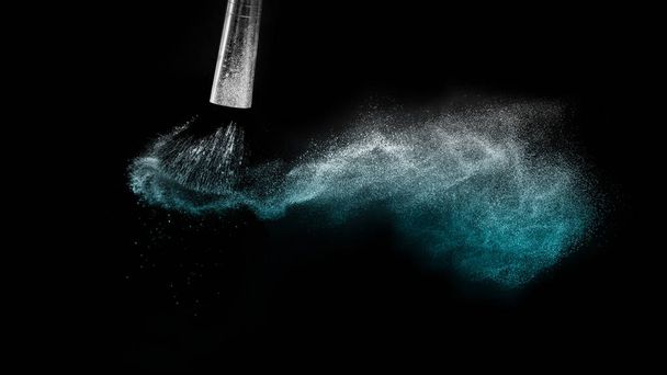 Pennello cosmetico con polvere cosmetica blu che si diffonde per il trucco ar
 - Foto, immagini