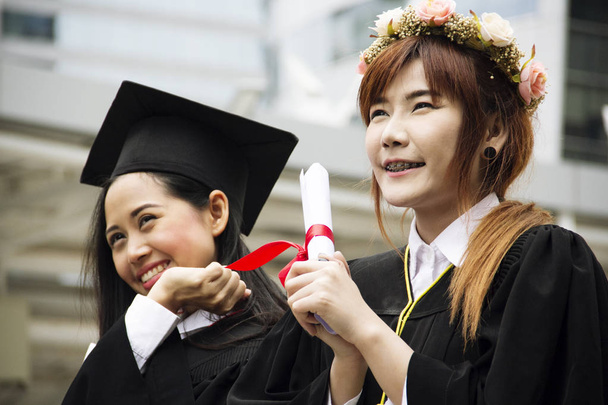 Beautiful absolwent absolwentów dwie Azja kobieta uśmiech i są szczęśliwi po ukończeniu studiów. - Zdjęcie, obraz