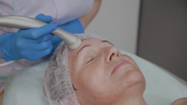 Cosmetologist profissional executa o procedimento para uma mulher idosa com microcorrentes no escritório de cosmetologia
. - Filmagem, Vídeo