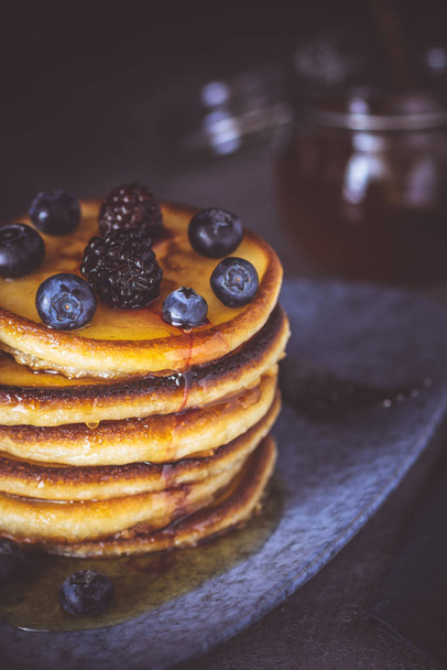 American Pancakes with Organic Berries and Maple Syrup on Dark Background. Classic Homemade Breakfast. - Fotoğraf, Görsel