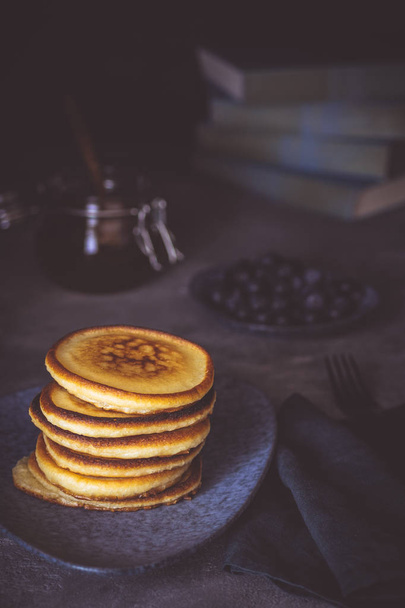 American Pancakes with Organic Berries and Maple Syrup on Dark Background. Classic Homemade Breakfast. - 写真・画像