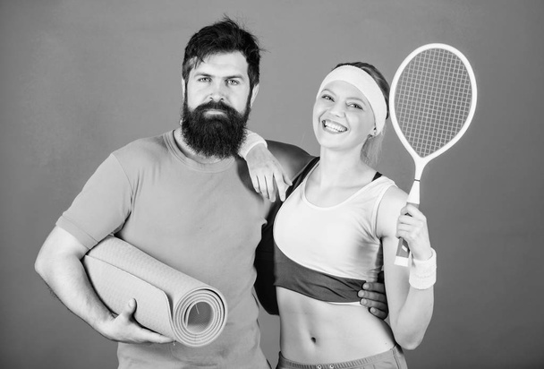 Sporty couple training with fitness mat and tennis racket. Sport equipment. Athletic Success. Happy woman and bearded man workout in gym. Strong muscles and body. Play like you re in first. - Foto, immagini