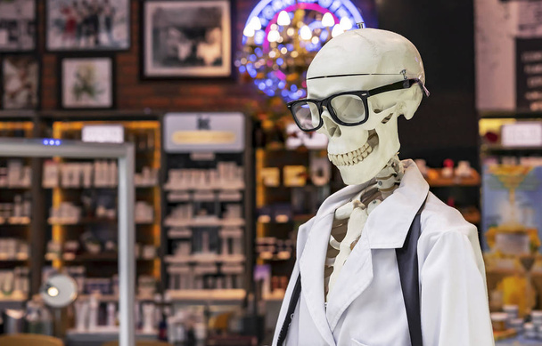 Esqueleto humano em um vestido médico branco e óculos pretos
. - Foto, Imagem