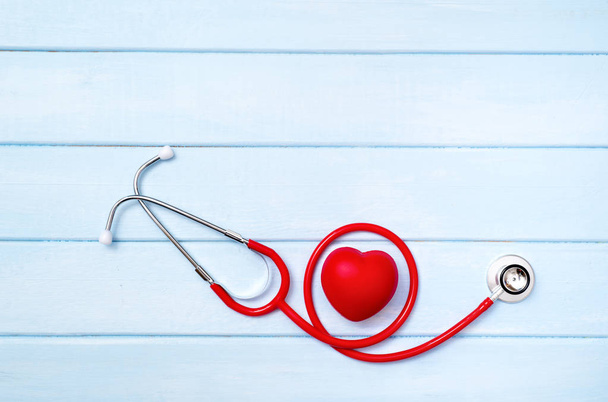Stethoscope and red heart on blue wooden background - Fotoğraf, Görsel