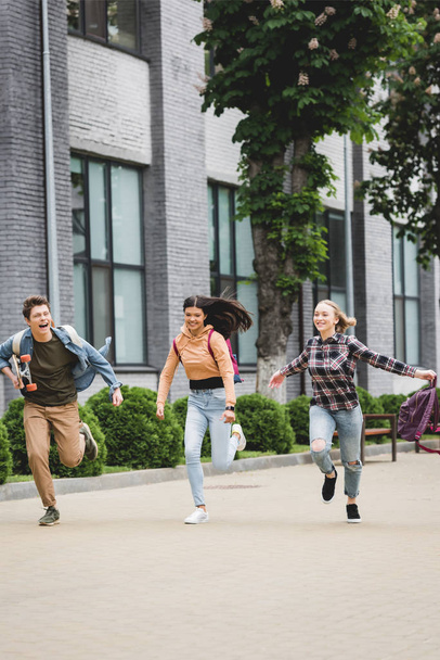 игривые и счастливые подростки бегают со скейтбордом и улыбаются
  - Фото, изображение