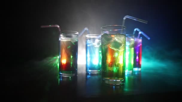 Vijf cocktails op de balk met rook op donkere achtergrond. Geel, groen en blauw gekleurde glazen. - Video