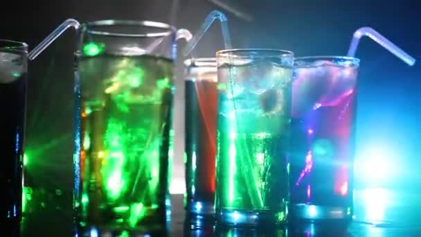 Cinque cocktail al bar con fumo su sfondo scuro. Occhiali di colore giallo, verde e blu
. - Filmati, video