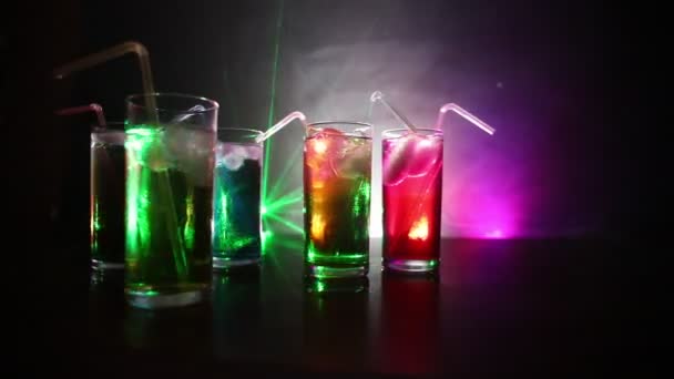 Fünf Cocktails an der Bar mit Rauch auf dunklem Hintergrund. gelbe, grüne und blaue Gläser. - Filmmaterial, Video