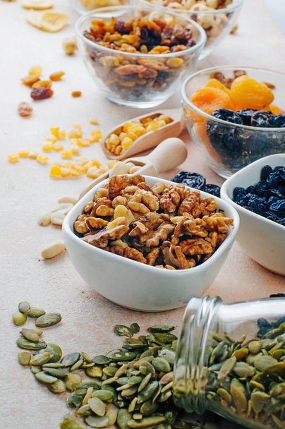 Detailní záběr sušeného ovoce, ořechů a semen ve skleněných miskách  - Fotografie, Obrázek