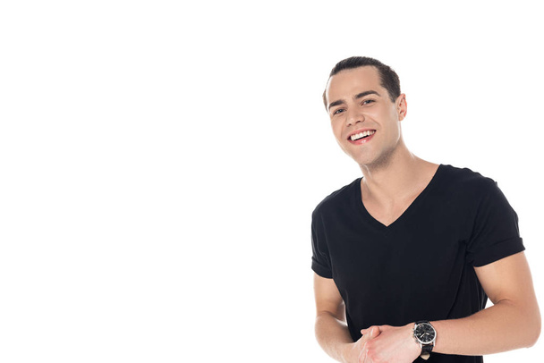 όμορφος μελαχρινή νέος άντρας με μαύρο μπλουζάκι χαμογελώντας και κοιτώντας την κάμερα απομονωμένη σε λευκό - Φωτογραφία, εικόνα