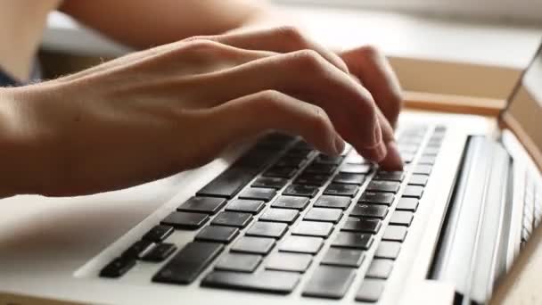 Primer plano de una joven escribiendo en un teclado portátil - Imágenes, Vídeo