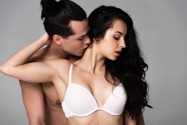 сексуальный мужчина без рубашки обнимает и целует сексуальную девушку изолированную от серых
 - Фото, изображение