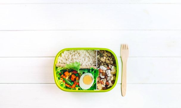 Lunchbox und Gabel auf weißem Holzhintergrund mit Kopierraum - Foto, Bild