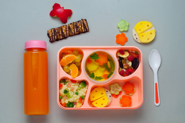 Обеденная коробка с фруктами, супом, кусочком салата и забавными бутербродами - Фото, изображение