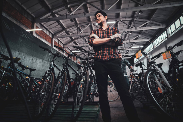 Fiatal vonzó férfi pózol kerékpár raktárak fotós. - Fotó, kép