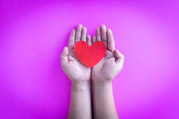 child hands holing red paper heart - Foto, imagen