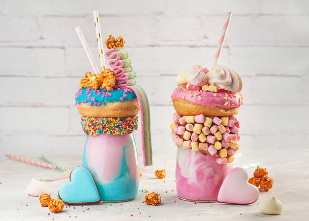 Twee freakshakes belegd met donut, marshmallow, popcorn en ma - Foto, afbeelding