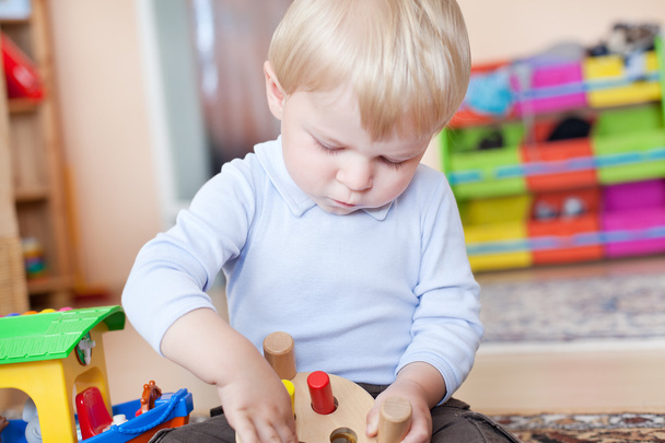 Pequeño niño jugando con juguetes de madera
 - Foto, Imagen