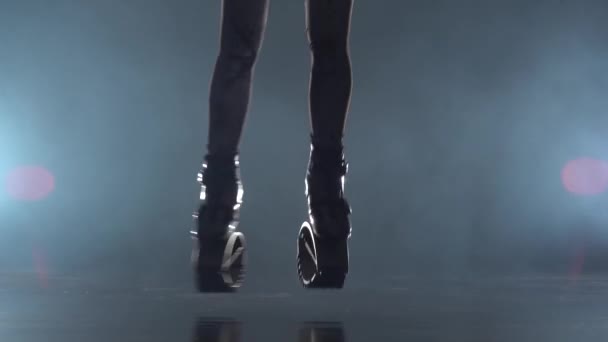 Close-up motion of legs in kangoo jumps shoes at studio with haze - Materiał filmowy, wideo