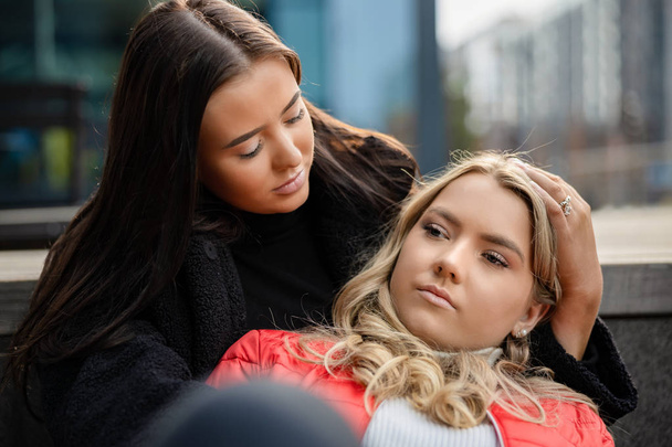 Young Woman Consoling Sad Friend In City - 写真・画像