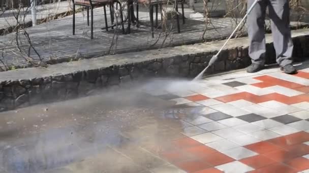 Man worker cleaning city dirty streets with high pressure and temperature - Materiaali, video