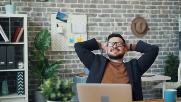Happy businessman relaxing in office enjoying work break smiling sitting - Кадри, відео