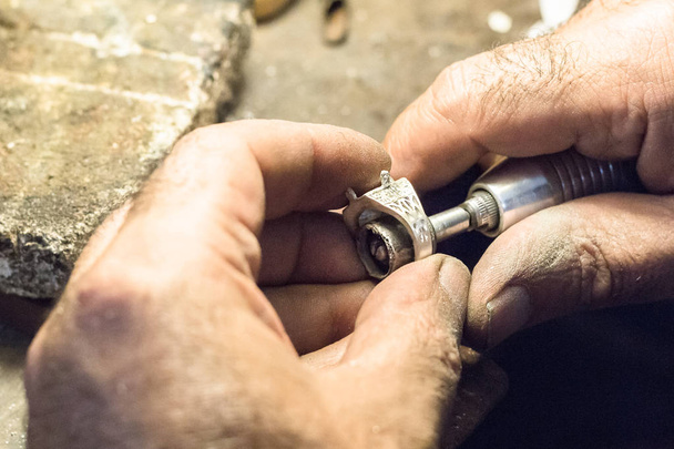 Juwelier poliert Ring mit Schleifpapier auf Schlitzdorn. - Foto, Bild
